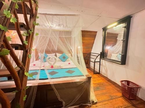 a bedroom with a bed with a canopy at Levona Garden Resort in Habarana