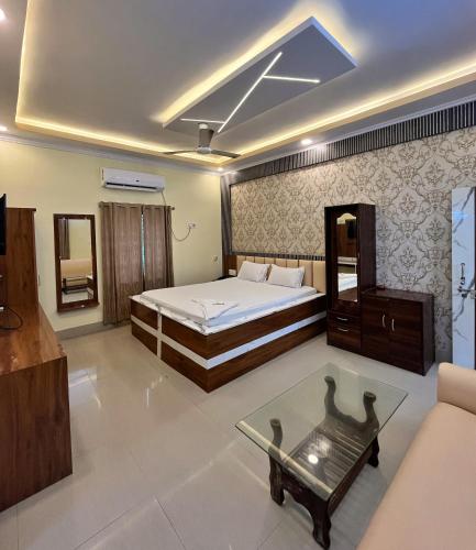 a bedroom with a bed and a tv and a couch at Sunview Resort in Mandarmoni