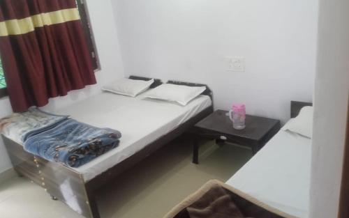 a small bedroom with a bed and a table at Hotel Sarthak Bed n Breakfast by StayApart in Phata