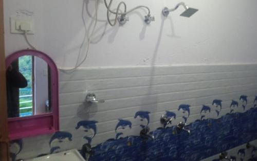 a bathroom with a shower with ducks on the wall at Hotel Sarthak Bed n Breakfast by StayApart in Phata