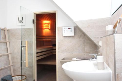 a bathroom with a sink and a toilet and a staircase at In den Katen in Wieck