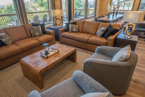 a living room with couches and a coffee table at Luxury 12-Bedroom Cabin with Indoor Pool, Hot tub & Movie Theater, Sleeps 36 in Sevierville