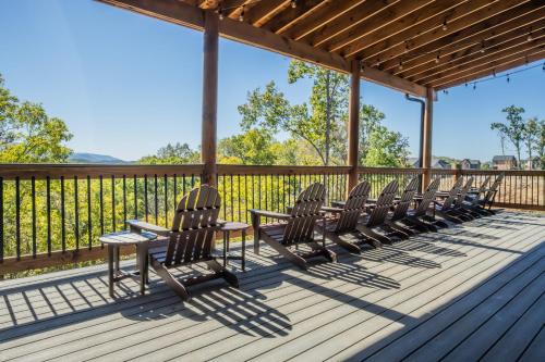 a row of chairs sitting on a deck at Luxury 12-Bedroom Cabin with Indoor Pool, Hot tub & Movie Theater, Sleeps 36 in Sevierville