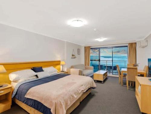 a hotel room with a bed and a living room at The Entrance Waterfront Resort, Unit 614 in The Entrance