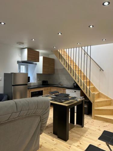 Il comprend une cuisine et un salon avec une table et un escalier. dans l'établissement Grange entièrement rénovée à Chanac wifi gratuit, à Chanac