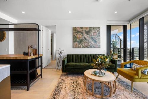 a living room with a green couch and a table at Skyline Retreat - 2BR Luxury City Apartment in Adelaide