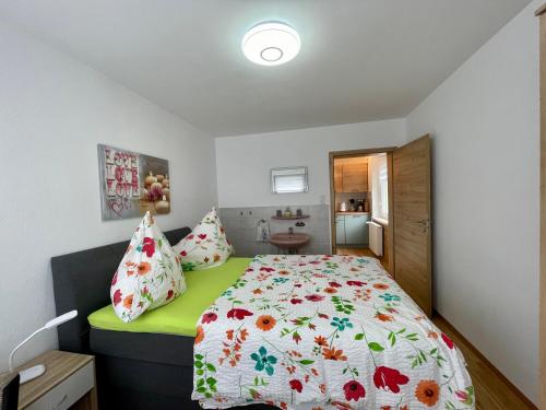 una camera da letto con un letto con una coperta a fiori di Ferienwohnung Dorfblick Bad Bocklet a Bad Bocklet