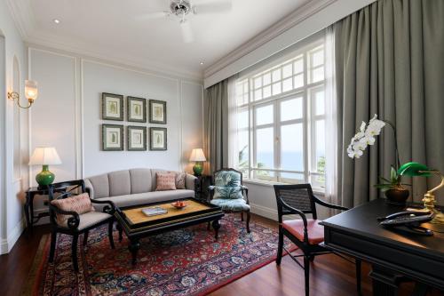 a living room with a couch and a table at Eastern & Oriental Hotel in George Town
