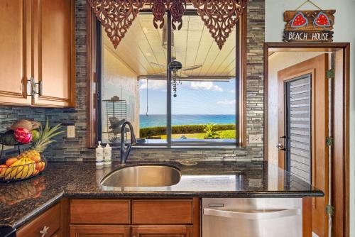 eine Küche mit einem Waschbecken und ein Fenster mit Aussicht in der Unterkunft Poipu Makai Villas C1 in Koloa