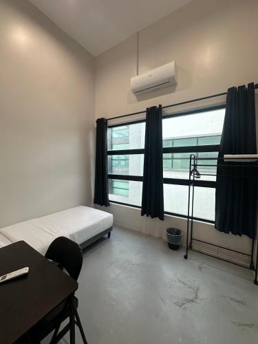 a bedroom with a bed and a desk and a window at Be Right Back Loft - Alma in Kampong Ayer Merah