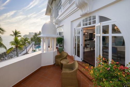 a balcony with chairs and a view of the ocean at Eastern & Oriental Hotel in George Town
