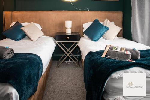 Zimmer mit 2 Betten und blauen und weißen Kissen in der Unterkunft Riya Apartments 2 Bedroom- Wifi-Free Parking in Lemington