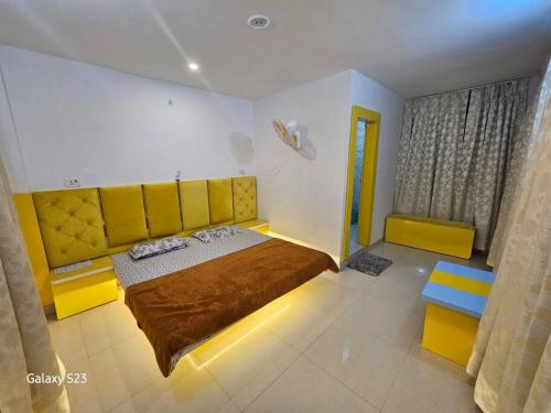 1 dormitorio con cama grande y cabecero amarillo en The OrtusStays - Sunrise Room, en Orchha