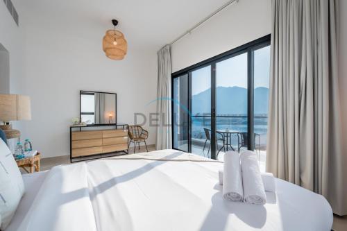 a bedroom with a bed with a view of the ocean at Best Deal 3BR plus maid's with Pool Perfect for Groups by Deluxe Holiday Homes in Fujairah