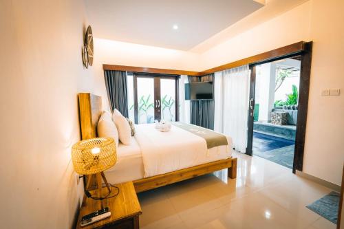 a bedroom with a bed and a large window at Villa Umah Seminyak in Seminyak