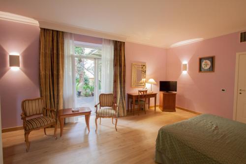 um quarto com uma cama, uma secretária e uma janela em Ateneo Garden Palace em Roma