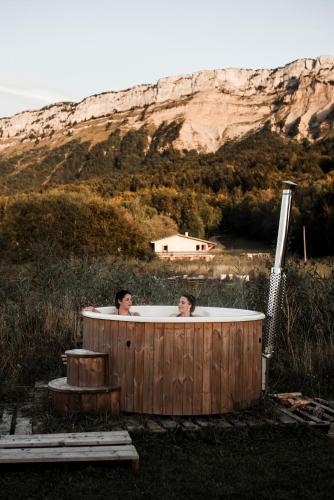 two people in a hot tub in a field at le chalet de Plainpalais in Les Déserts