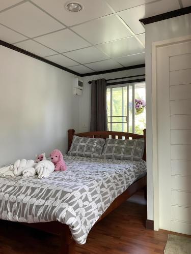 two stuffed animals sitting on a bed in a bedroom at Sroysuwan Pool villa in Khanom