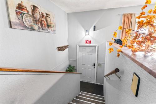 a hallway with stairs and a door with an exit sign at ShaligoHomes Sunset Room On 6th Ave in Anchorage