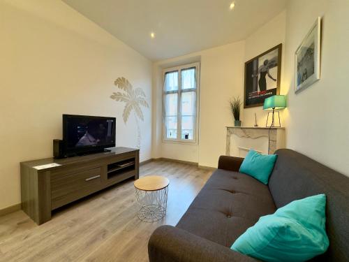 un salon avec un canapé et une télévision dans l'établissement Vénus By SCLS Locations, à Cannes