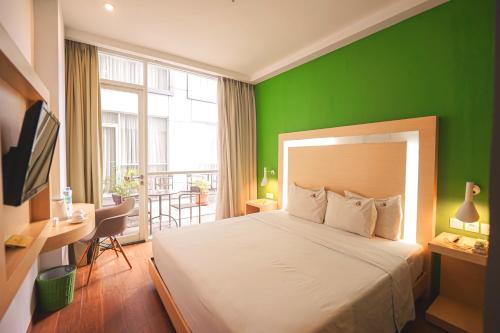 a green bedroom with a bed and a green wall at DK Belstar Hotel Belitung in Tanjungpandan