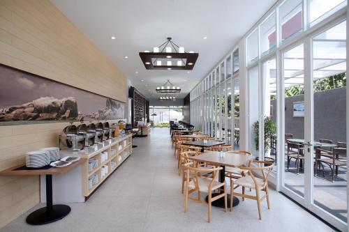 a restaurant with tables and chairs and windows at DK Belstar Hotel Belitung in Tanjungpandan