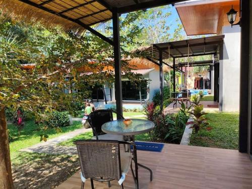 a patio with a table and chairs on a deck at Ingtara at Lanta in Ko Lanta
