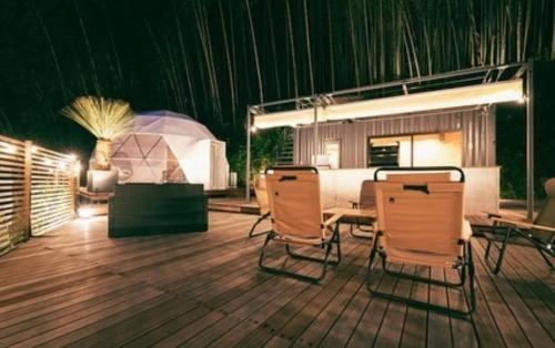 a room with a table and chairs on a wooden floor at ODEON Gongen松山市一組限定貸切グランピング in Horiechō