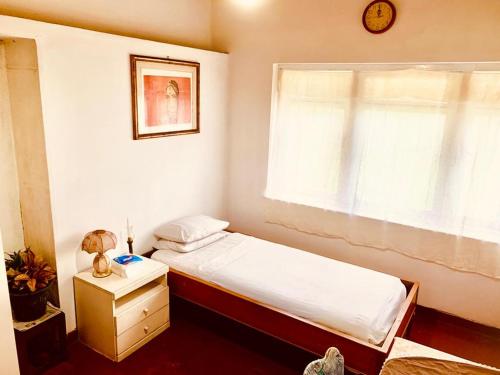 a small bedroom with a bed and a window at No 06 Veediya Bandara Lane Bahirawakanda in Kandy