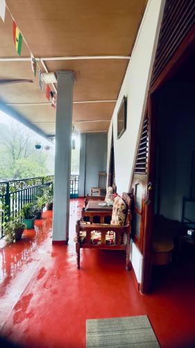 a living room with a red floor and a staircase at Singh Brothers in Adams Peak