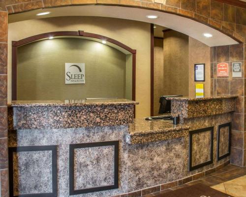 a hotel lobby with a reception counter with a mirror at Sleep Inn & Suites at Six Flags in San Antonio