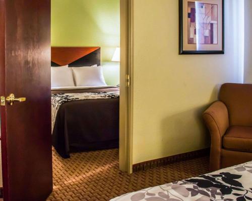 a door to a room with a bed and a chair at Sleep Inn & Suites at Six Flags in San Antonio