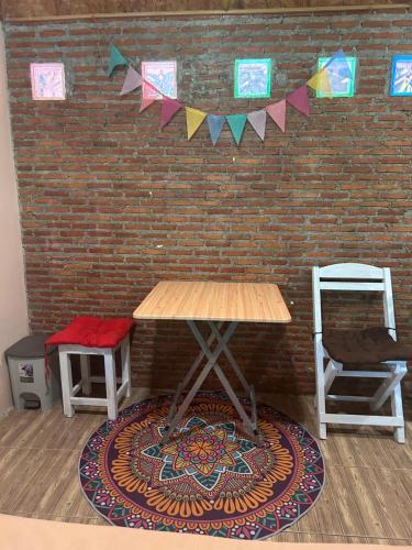 a room with a table and a brick wall with flags at Hippy Hut Koh Chang in Ko Chang