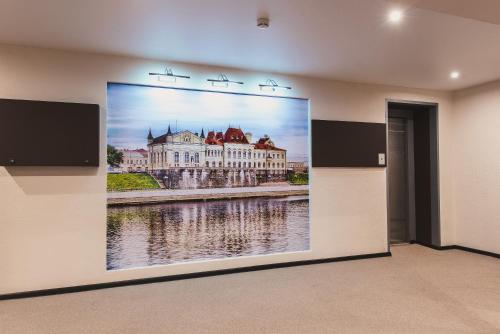 a wall with a large picture of a building at Hotel Complex Rybinsk in Rybinsk