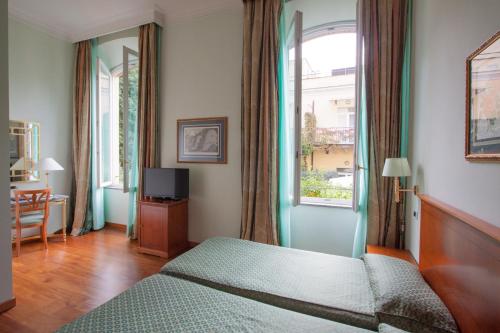 a bedroom with a bed and a window at Ateneo Garden Palace in Rome