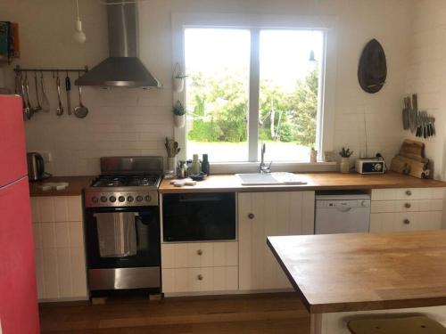 a kitchen with a stove and a sink and a window at Redruth,original 1940 Falmouth shack in Falmouth
