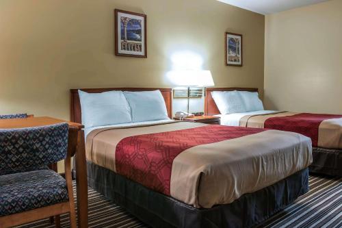 a hotel room with two beds and a chair at Econo Lodge in Paw Paw