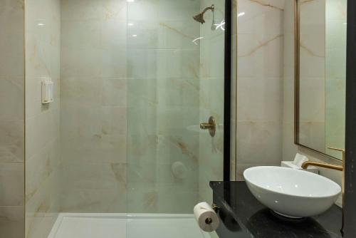a bathroom with a sink and a glass shower at Halifax Tower Hotel & Conference Centre, an Ascend Collection Hotel in Halifax
