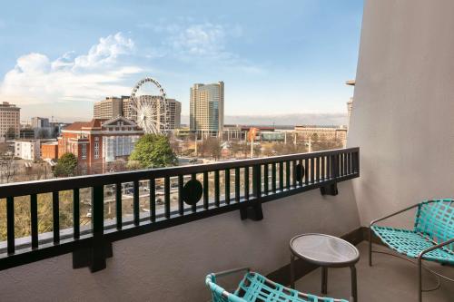 a balcony with chairs and a view of the city at The American Hotel Atlanta Downtown, Tapestry Collection by Hilton in Atlanta