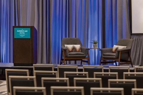 a row of chairs in a room with blue curtains at The American Hotel Atlanta Downtown, Tapestry Collection by Hilton in Atlanta