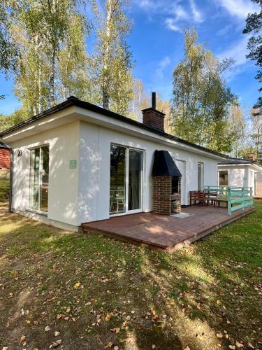 a white house with a deck and a fireplace at Lake Park Łagów in Łagów