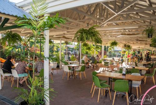 a patio of a restaurant with tables and chairs at Cairns Colonial Club Resort in Cairns