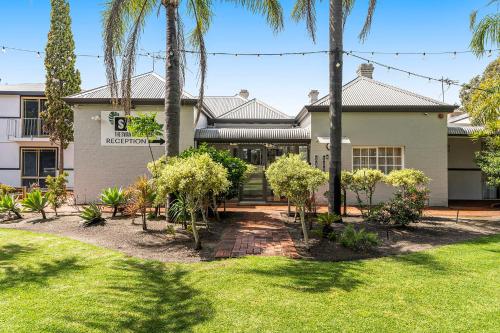 a house with palm trees in front of it at The Swan Valley Hotel in Henley Brook