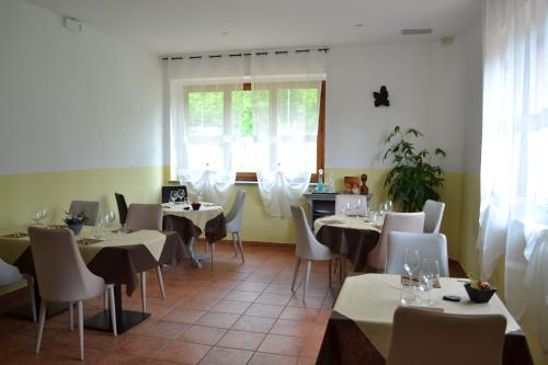 a restaurant with tables and chairs and a window at Ai canipai in San Romano in Garfagnana