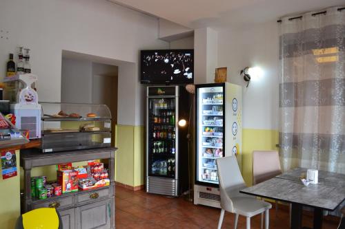a kitchen with a refrigerator and a table and a dining room at Ai canipai in San Romano in Garfagnana