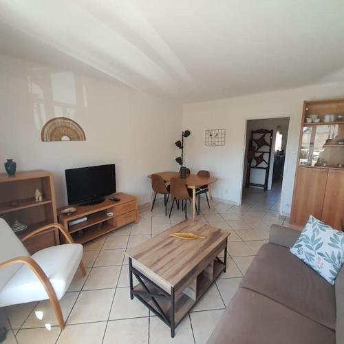 a living room with a couch and a table at Petit Coin de Paradis 2 MN de la mer 2chs balcon clim parking in Six-Fours-les-Plages
