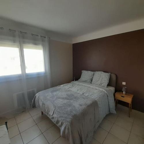 a bedroom with a large bed and a window at Petit Coin de Paradis 2 MN de la mer 2chs balcon clim parking in Six-Fours-les-Plages