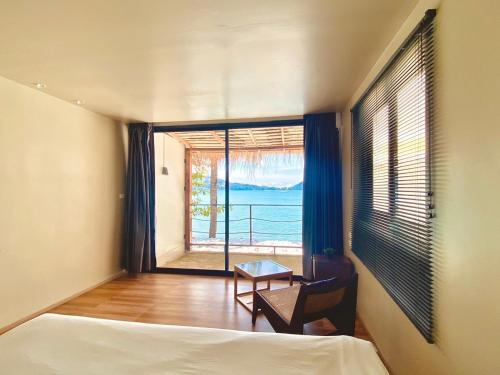 a bedroom with a bed and a view of the ocean at patong sunset villa Phuket in Patong Beach