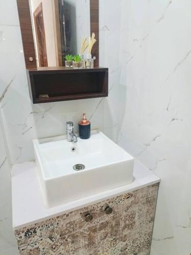 a bathroom with a white sink and a mirror at 58 Paraiso Villa in Udaipur