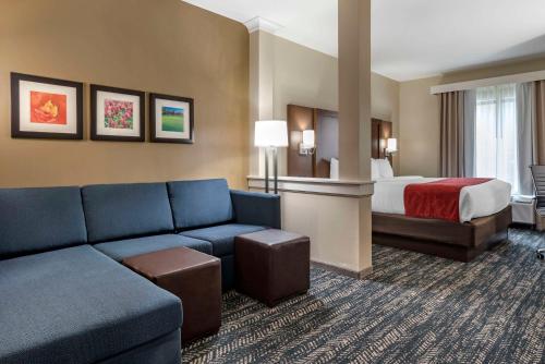 a hotel room with a bed and a couch at Comfort Inn & Suites Downtown near University in Tuscaloosa